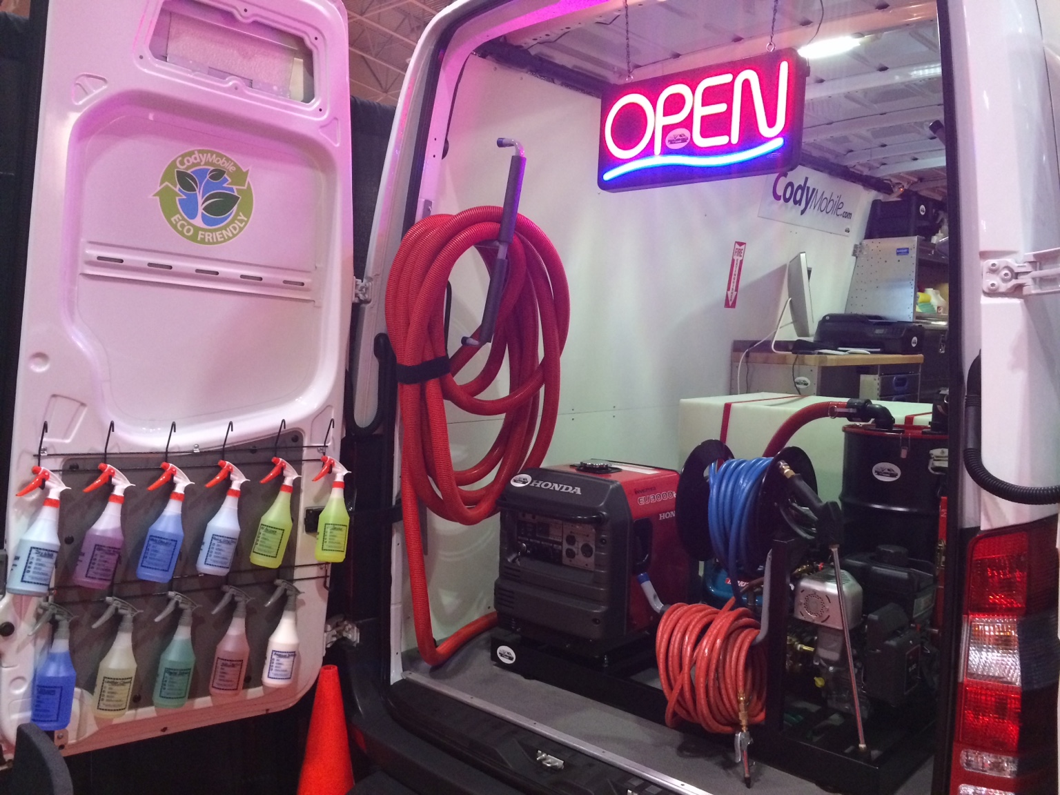 Inside the Cody Mobile detailing truck, with cleaning products, hose reels, a water tank and a generator